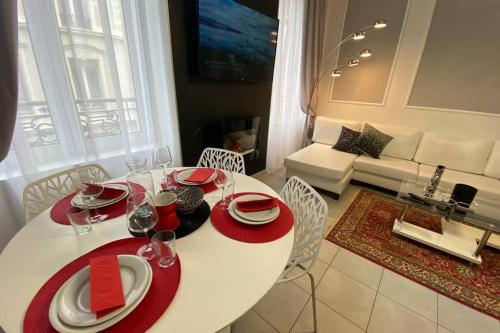 - une table blanche avec des assiettes rouges et des verres à vin dans le salon dans l'établissement Esprit Luxe .... au coeur de Mulhouse, à Mulhouse