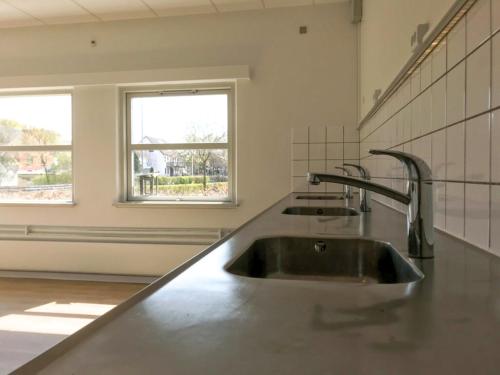 a kitchen with two sinks and a window at Djurs Housing in Trustrup