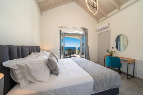 a bedroom with a bed and a desk and a view of the ocean at Villa Loel in Fiskardho