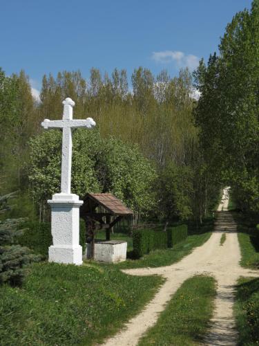 a white cross on the side of a dirt road at TITI House in Bakonykoppány