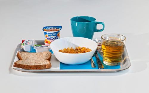 a tray with a bowl of cereal and a glass of beer at ibis budget Antony Massy rénové 2024 in Antony