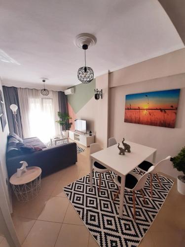 uma sala de estar com um sofá azul e uma mesa em Sweet Apartment em Tessalônica