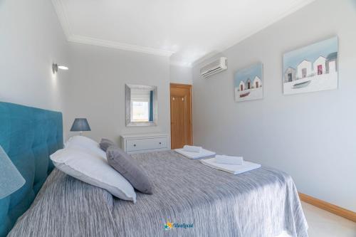 a white bedroom with a bed with pillows at Rotunda da Marina in Portimão