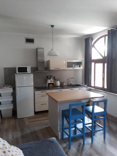 a kitchen with a table and two blue chairs at Apartment Mamut in Premantura