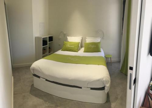 a bedroom with a large bed with green pillows at Cassis Lodges in Cassis
