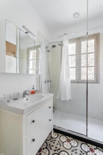 une salle de bain blanche avec un lavabo et une douche dans l'établissement Dame de Coeur - Appartement spacieux en plein centre historique, à Rennes