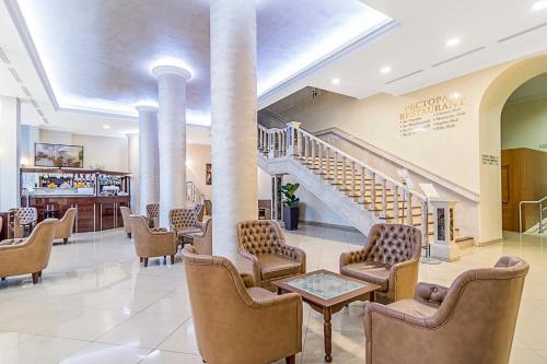 a lobby with chairs and stairs in a building at Ukraine Hotel in Kyiv