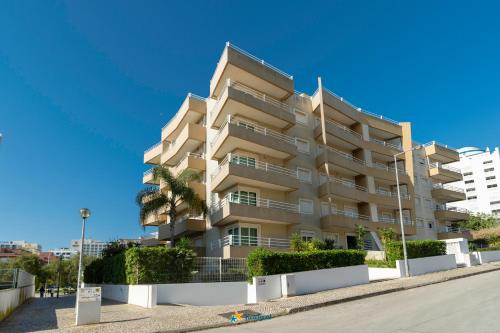 a tall apartment building with a palm tree in front of it at Rotunda da Marina in Portimão