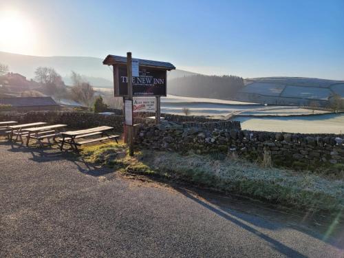 a group of benches sitting in front of a sign at New Inn Appletreewick in Appletreewick