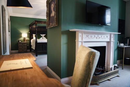 a dining room with a table and a fireplace at The White Hart Hotel in Kingston upon Thames
