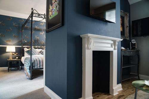a bedroom with blue walls and a bed with a mirror at The White Hart Hotel in Kingston upon Thames