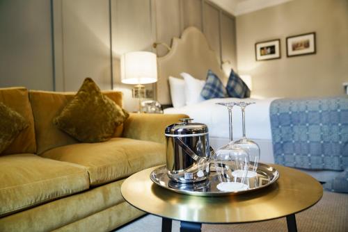 a hotel room with a couch and a bed at The White Hart Hotel in Kingston upon Thames