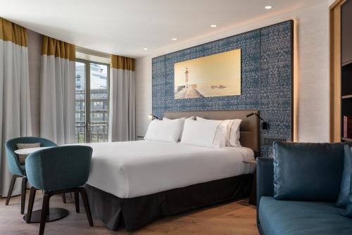 a hotel room with a bed and a couch at Eurostars Aliados in Porto