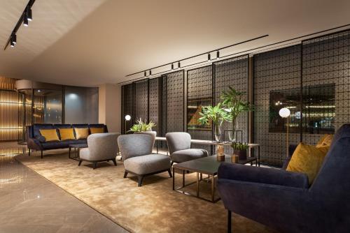 a lobby with couches and a table and chairs at Eurostars Aliados in Porto