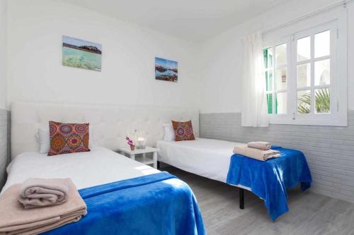 sypialnia z dwoma łóżkami i oknem w obiekcie Apartamento Coral Bay II by Vacanzy Collection w Corralejo