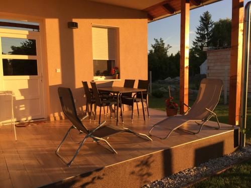 a patio with a table and chairs on a porch at Konrad Apartman in Balatonmáriafürdő