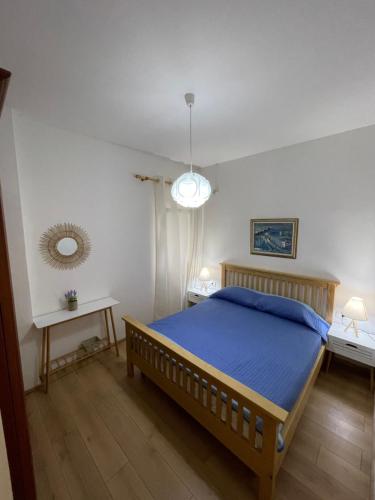 una camera con un letto blu e due tavoli di Gjiri Lalzit Apartment a Durrës