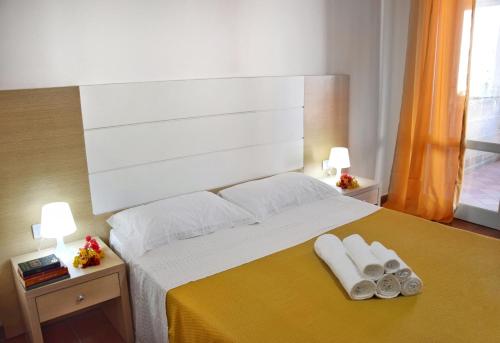 a bedroom with a large bed with two towels on it at Favignana Casa Vacanza Orsola in Favignana