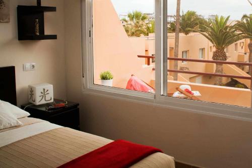 a bedroom with a bed and a window with a view at Apartamento Kalma by Vacanzy Collection in Corralejo