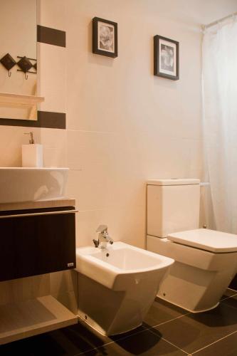 a bathroom with a white toilet and a sink at Apartamento Kalma by Vacanzy Collection in Corralejo