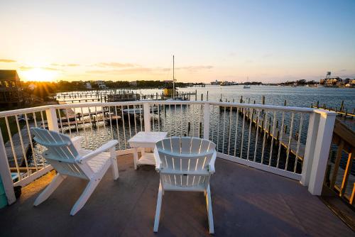 two chairs and a table on a balcony overlooking the water at The Ocracoke Harbor Inn in Ocracoke