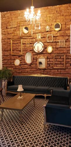 a room with couches and mirrors on a brick wall at La Casa del General Hotel Boutique in Hidalgo del Parral