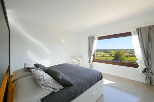een slaapkamer met een bed en een groot raam bij Finca Son Vador in Santa Margalida