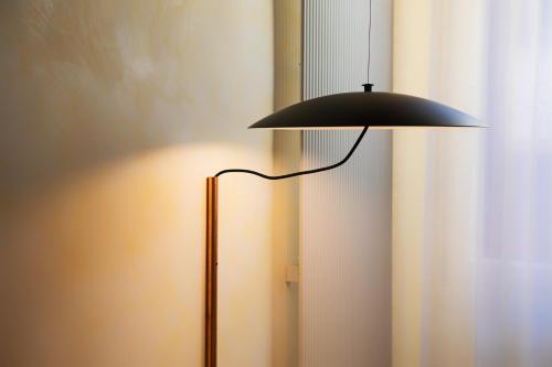 a black lamp sitting next to a window at 1881 LUXURY SUITES in Verona