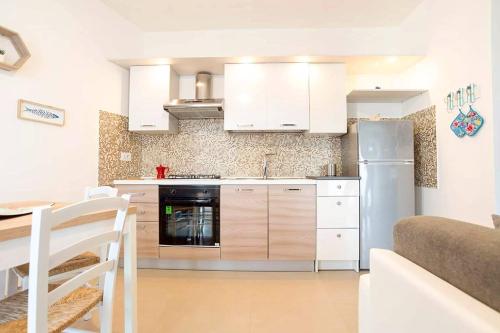 eine Küche mit weißen Schränken und einem Kühlschrank aus Edelstahl in der Unterkunft Mar&Co in Polignano a Mare
