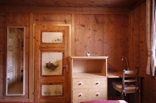 a room with a wooden wall with a cabinet and a door at Baita De Anna in Valdidentro