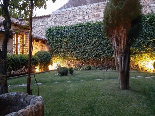 un jardín con una pared de hiedra junto a un edificio en La Victoria - Mirador de Pedraza, en Pedraza-Segovia