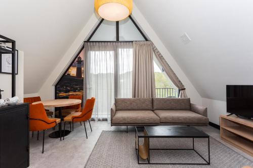 a living room with a couch and a table at Hotel Zeeuws Licht I Kloeg Collection in Dishoek