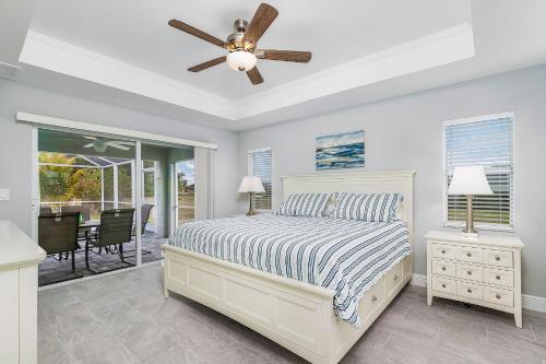 een slaapkamer met een bed en een plafondventilator bij Newly built home with heated pool, close to many amenities - Villa Sandle in Cape Coral