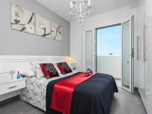 コラレホにあるApartamento Coral Bay by Vacanzy Collectionのベッドルーム1室(赤い毛布とシャンデリア付きのベッド1台付)