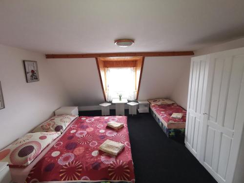 a small room with two beds and a window at Penzion Tomy Pihlov in Horní Planá