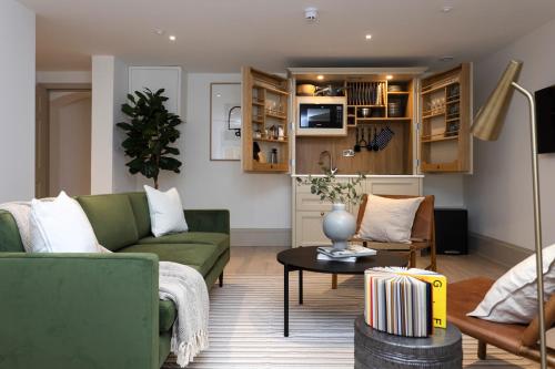 a living room with a green couch and a table at 29 Queen Street Luxury Flats in Edinburgh