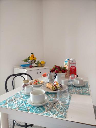 a table with food on it with bowls and cups at Residence Esmeraldo in Capo Vaticano