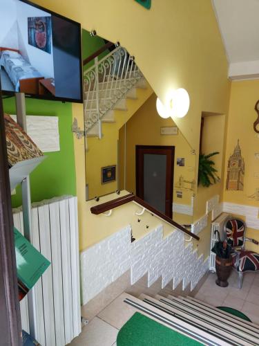 Cette chambre est dotée d'un escalier en colimaçon et d'un mur vert. dans l'établissement Domus Pacis Santa Chiara casa per ferie, à Loreto