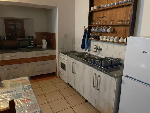 una cucina con lavandino e frigorifero bianco di Fisherman's Cottage a Hondeklipbaai