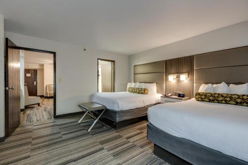 a hotel room with two beds and a chair at Alexis Inn and Suites Hotel in Nashville