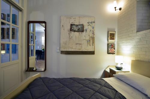 um quarto com uma cama e um espelho na parede em Vergeta apartment em Corfu Town
