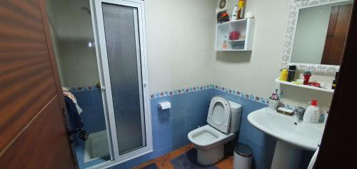 a blue and white bathroom with a toilet and a sink at Belle appartement de vacances avec vue sur mer in Tétouan