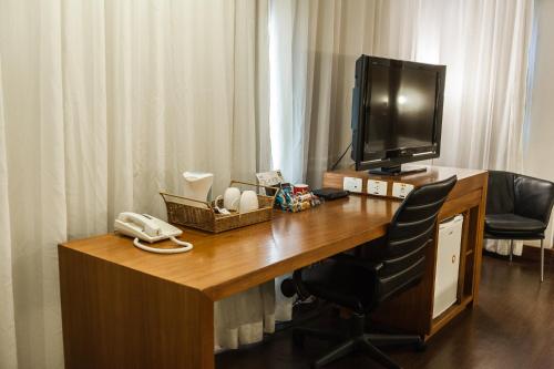 a desk with a monitor, keyboard and mouse on it at Quality Porto Alegre in Porto Alegre