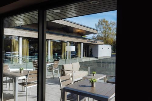 a patio with tables and chairs in front of a building at The Redhurst Hotel Glasgow in Giffnock