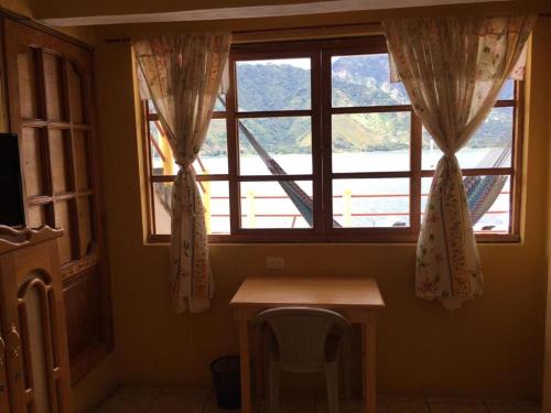 um quarto com uma mesa e uma janela em Hotel Villa del Lago em San Pedro La Laguna