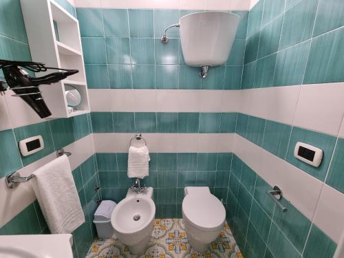 トロペアにあるLady Saturno's Homeの緑のタイル張りのバスルーム(トイレ、シンク付)