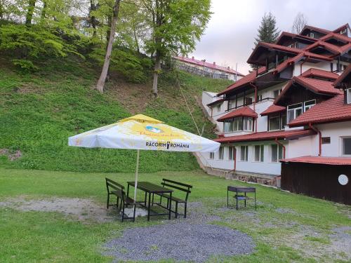 a table and chairs under an umbrella in a yard at Cristal Sinaia in Sinaia