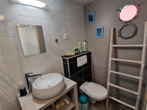 een badkamer met een wastafel, een toilet en een ladder bij Bungalow La Perle - Jacuzzi - Piscine in Saint-François