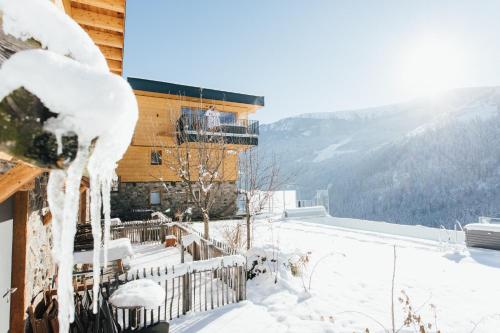 a snow covered house with a balcony with a view at Boutique Apartment Sonnenhang - incl InfinityPOOL in Fliess