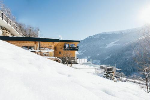 a building on top of a snow covered mountain at Boutique Apartment Sonnenhang - incl InfinityPOOL in Fliess
